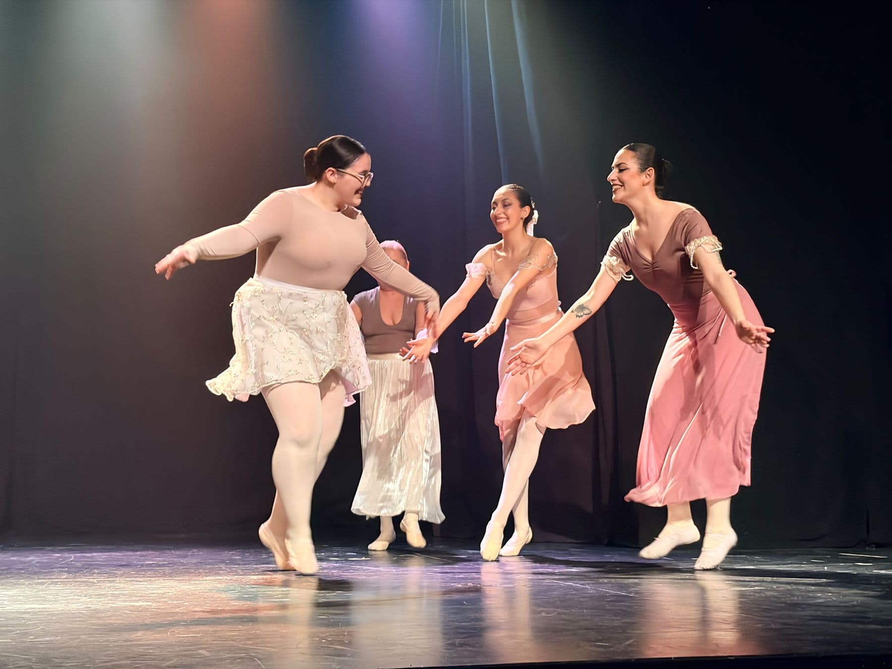 Alumnas de Isadora bailando y sonriendo en el escenario